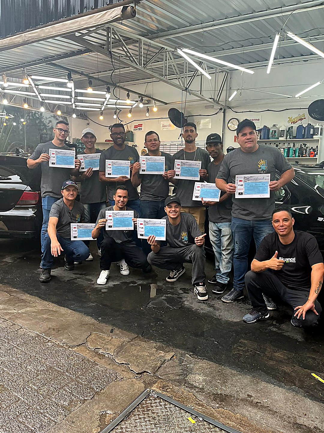 Turma do curso de estética automotiva de 14/09/2024 segurando os certificados na oficina Wash